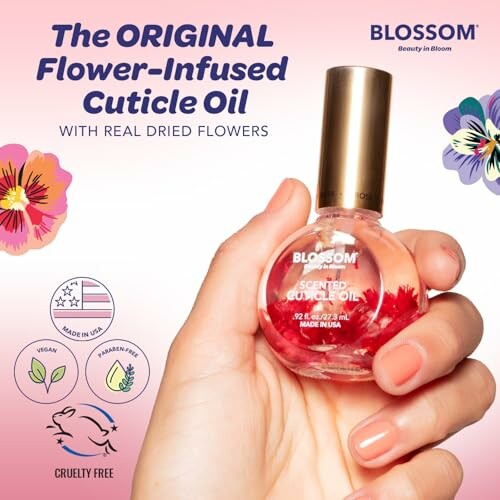 Hand holding Blossom scented cuticle oil with real dried flowers.